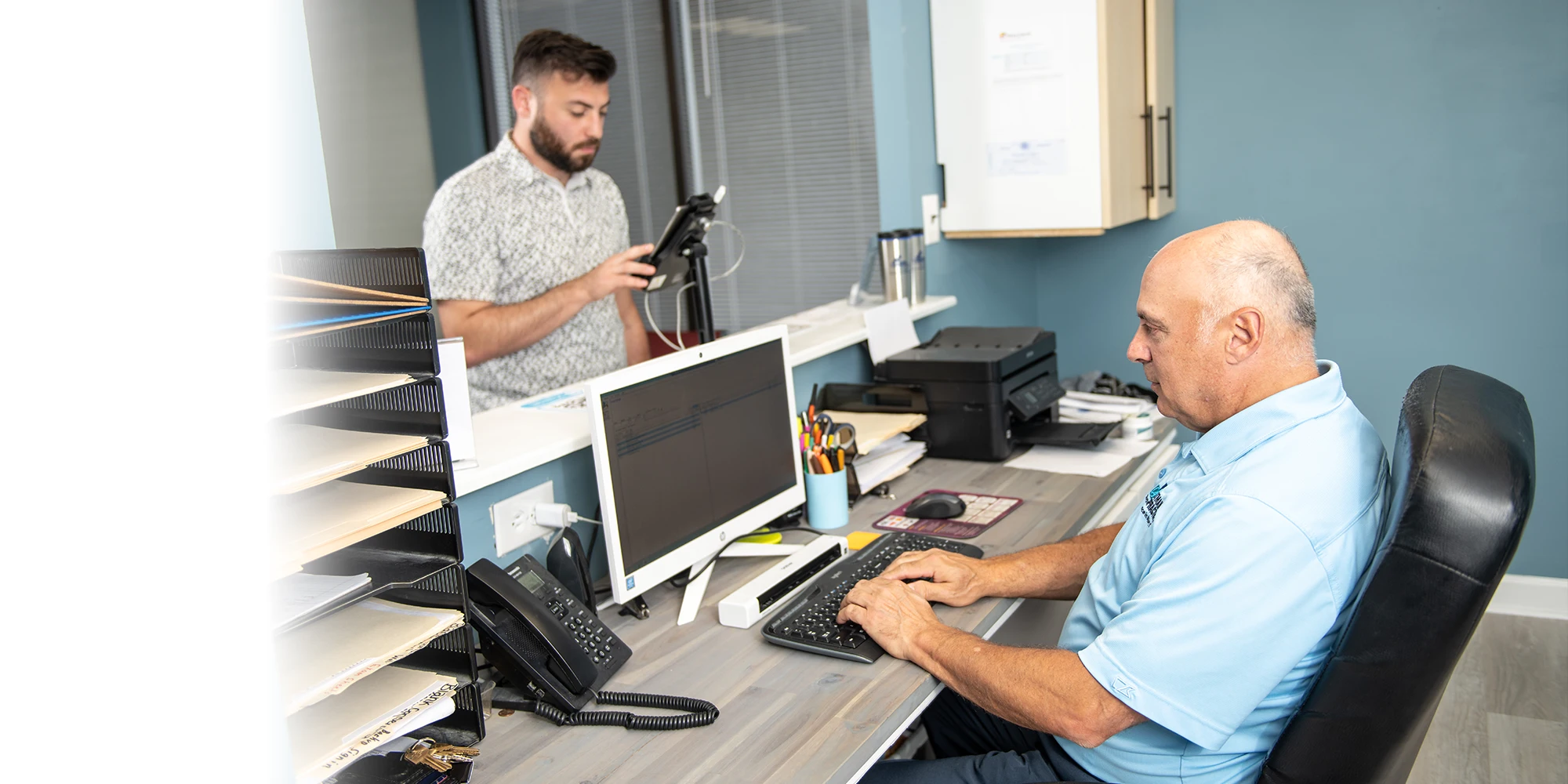 Chiropractor Laurel MD Mark Stutman At Front Desk With Patient