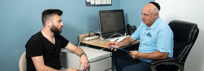 Chiropractor Takoma Park MD Mark Stutman Consulting With Patient