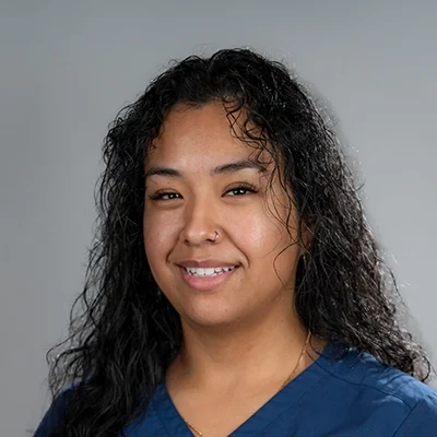 Berenice Zuniga smiling in blue scrubs.
