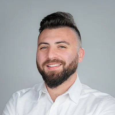 Hillel Stutman smiling in a white collared shirt.